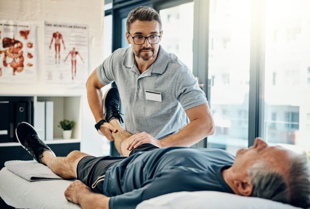 Fysioterapeutti laatii asiakkaalle yksilöllisen harjoitusohjelman. Kuvassa fysioterapeutti tutkii asiakasta.