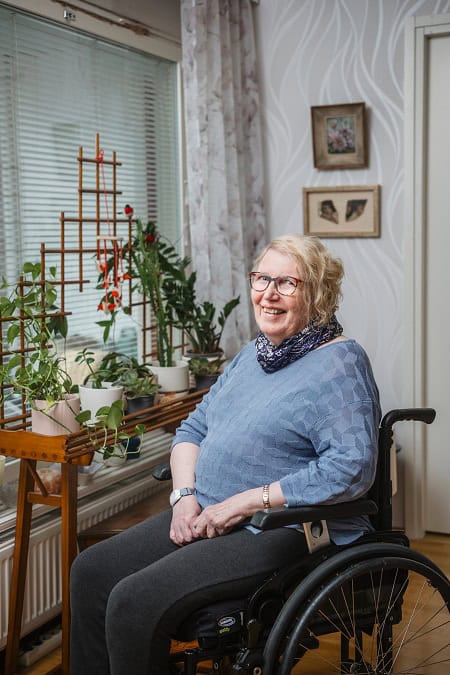 Suomen Seniorihoivan asiakas Arja hymyilee pyörätuolissa.