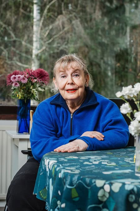 Suomen Seniorihoivan asiakas Kirsti hymyilee kahvipöydässä.